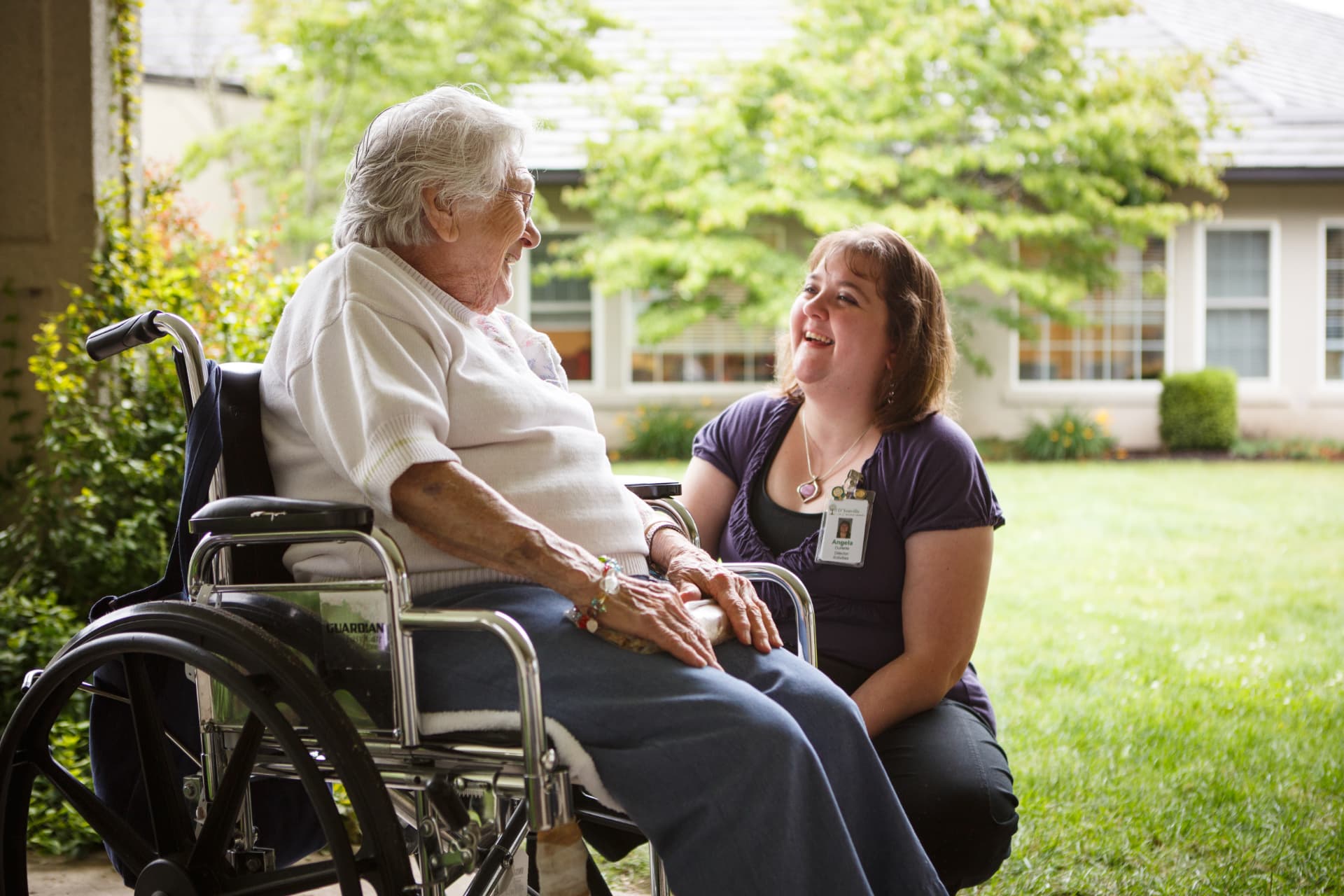 A caregiver and resident sharing a laugh outdoors